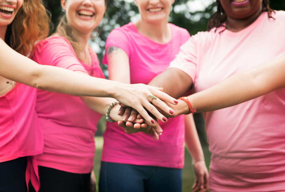quatro-mulheres-com-maos-unidas-pela-campanha-de-outubro-rosa